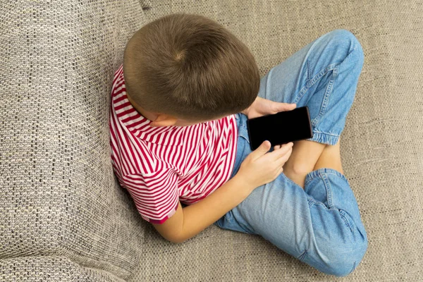 Мобільний телефон в руках хлопчика з чорним порожнім сенсорним екраном — стокове фото