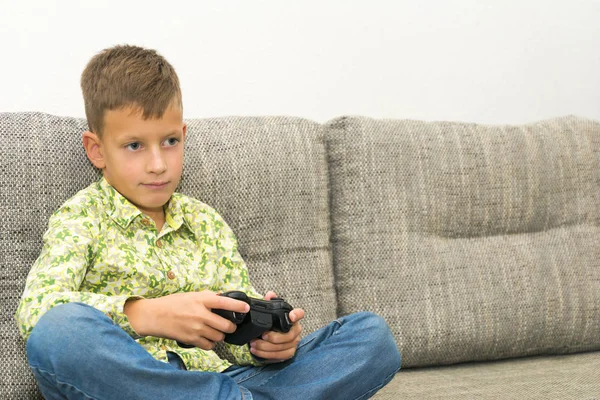 Jongen spelen van videospellen met joystic zittend op de Bank — Stockfoto