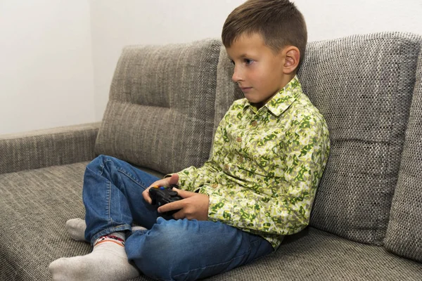 Jongen spelen van videospellen met joystic zittend op de Bank — Stockfoto