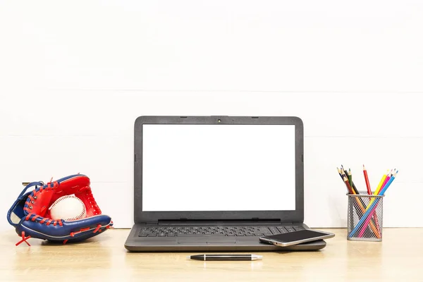 Laptop batjocură pe masă de lemn cu mănuși de baseball și minge, stilou, creioane colorate și telefon inteligent Spațiu de lucru în mansardă. Fotografie interioară — Fotografie, imagine de stoc