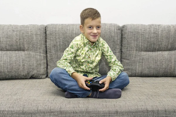 Niño jugando videojuegos con alegre sentado en el sofá — Foto de Stock