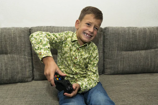 Jongen spelen van videospellen met joystic zittend op de Bank — Stockfoto