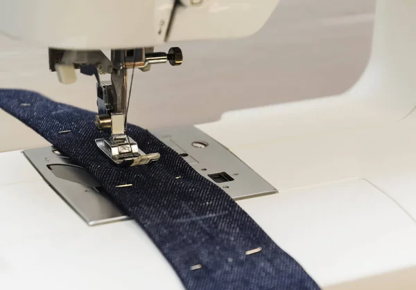 Close-up detail šicí stroje, modré džíny — Stock fotografie