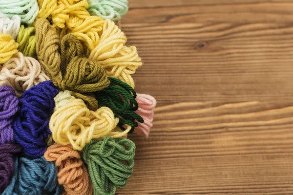 Barevné pletení vlákna na dřevěné pozadí — Stock fotografie