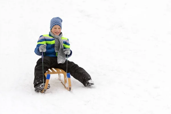 Kid deslizando com trenó na neve . — Fotografia de Stock