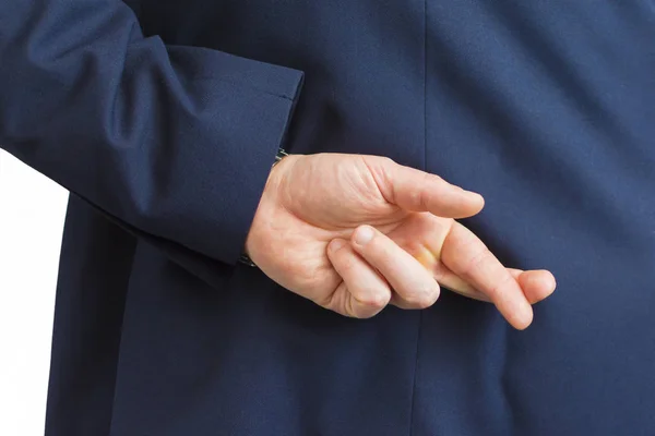 Closeup of a business man with his hands behind his back and fingers crossed. Stock Image