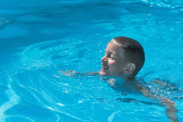 Jeune garçon nageant dans la piscine pour la première fois — Photo