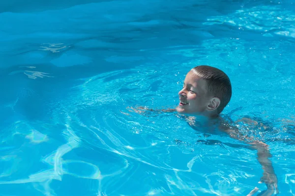 Jeune garçon nageant dans la piscine pour la première fois — Photo