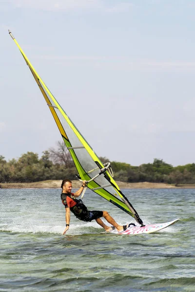 Lazurne Ukraine 09.09.2018 Side view of young man surfing the wind on summer day — Stock Photo, Image