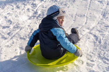 Cherkasy, Ukrayna - 01.05.2019 Bir kış günü tepelerden kayarak inen çocuk.