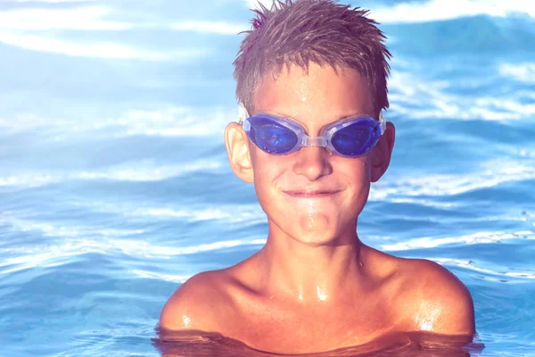 Joyeux garçon souriant dans des verres d'eau dans la piscine. fermer portreit — Photo