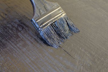 Ahşap arka planda siyah boya ve fırça