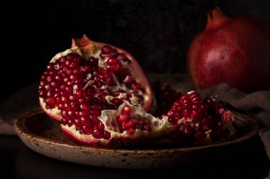 Koyu arka plan üzerinde kırmızı sulu Nar ile natürmort. Organik biyo meyve