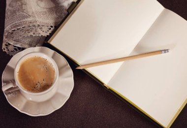 bir fincan kahve ve açık defter