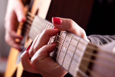 Kadın Close-Up akustik gitar çalmak eller
