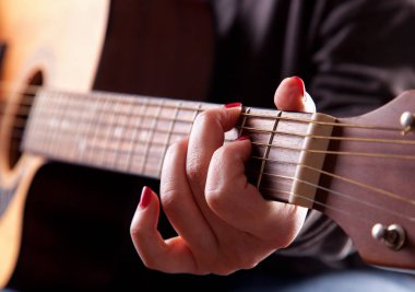 Kadın Close-Up akustik gitar çalmak eller