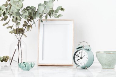 Poster çerçeve mockup, dekor öğeleri, çiçek ve boş kopya alanı beyaz duvara Önden Görünüm.