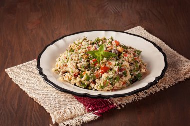 Tabbouleh - Orta Doğu vejetaryen tabağı kuskus, domates, maydanoz, Kuru üzüm ve zeytin yağı ve limon suyu ile mintseasoned kurumuş. Kolay otantik tarifi 