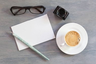 Düz boş oyun kağıdı-in yatıyordu; kahve fincanı; mürekkep ve kalem ile kopya alanı. En iyi veiw