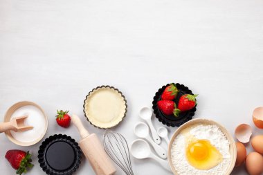 Mutfak eşyaları pişirme ve pişirme tart, tanımlama bilgileri, hamur ve pasta için malzemeler. Düz yumurta, un, şeker, çilek ile yatıyordu. Üstten Görünüm, mockup tarifi, blog pişirme mutfak sınıflar için.