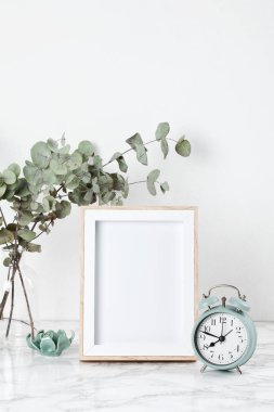 Poster çerçeve mockup, dekor öğeleri, çiçek ve boş kopya alanı beyaz duvara Önden Görünüm.