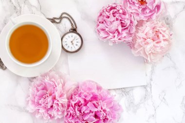 Çay saati. Düz peonies ve çay ile ışık arka plan üzerinde yatıyordu. Kopya alanı metin için