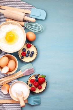 Mutfak eşyaları pişirme ve pişirme tart, tanımlama bilgileri, hamur ve pasta için malzemeler. Düz yumurta, un, şeker, çilek ile yatıyordu. Üstten Görünüm, mockup tarifi, blog pişirme mutfak sınıflar için.