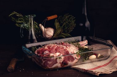 Taze çiğ kuzu bacak sarımsak ve otlar ile kavurma için hazır