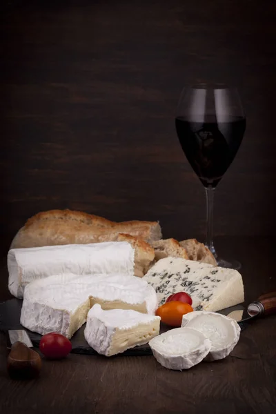 Variety of French cheeses with wine in glass