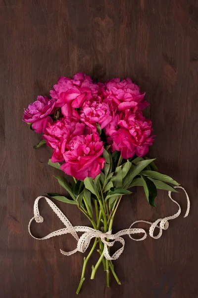 Ribbon in form of heart with bouquet of peonies. Concept of love, celebration, wedding, saint valentine\'s day. Top view