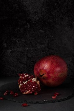 Koyu arka plan üzerinde kırmızı sulu Nar ile natürmort. Organik biyo meyve