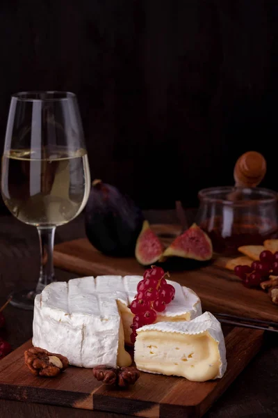 French creamy cow\'s milk cheese camembert served with wine and fruits