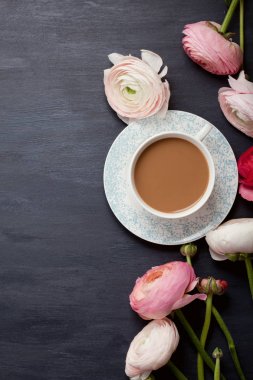 Pembe çiçekler ve sütlü kahve fincan üstten görünüm