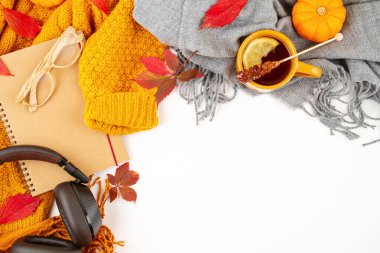 Sonbahar kompozisyonu sonbahar yaprakları, sıcak bir fincan çay ve sıcak yün turuncu bir kazak.