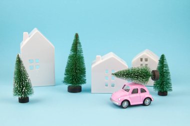 Küçük oyuncak araba çatıda noel ağacı taşıyor. Sessel tatiller, tebrik kartları