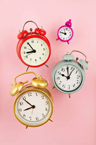 Coleção de relógios de alarme coloridos brilhantes sobre o fundo rosa — Fotografia de Stock