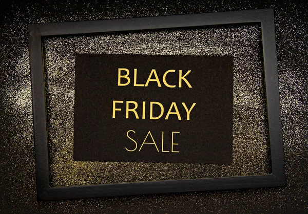 Чорний папір і рама з текстом Чорна п'ятниця продаж над золотим мерехтливим фоном — стокове фото