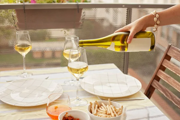 Femme versant du vin blanc aux verres à vin sur la terrasse — Photo