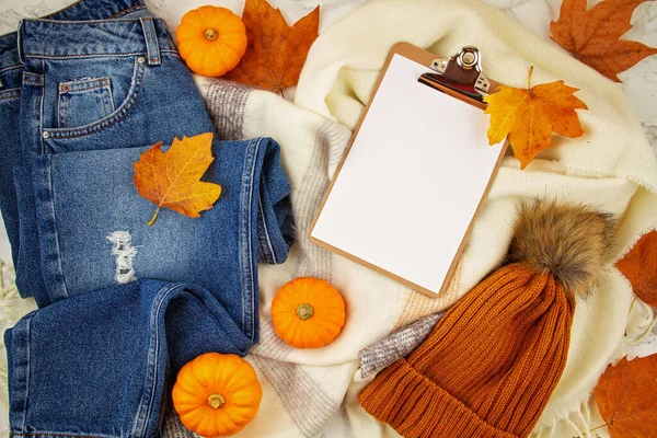 Flat lay composizione autunnale con foglie autunnali, zucche, jeans e una calda sciarpa di lana e cappello — Foto Stock