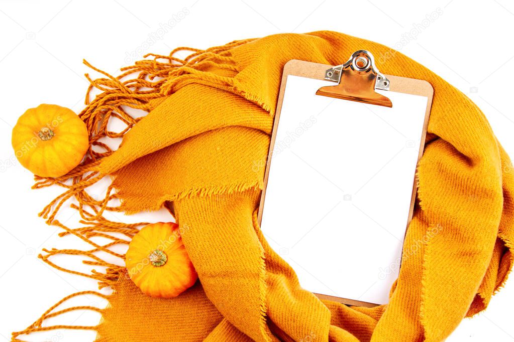 Flat lay autumn composition with notepad and a warm woolen scarf