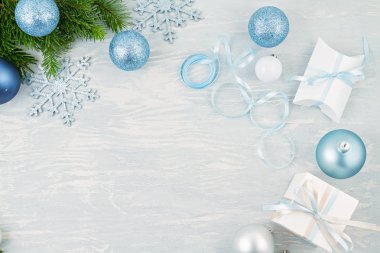 Mavi ve gümüş renkli Noel arkaplanı ve hediyeleri var.