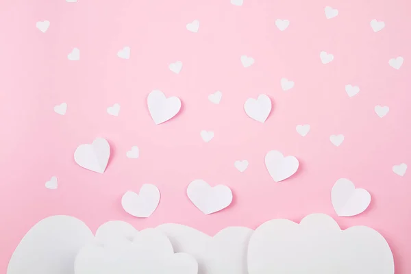 Corazones de papel y nubes sobre fondo rosa. Amor, San Valentín, día de la madre, tarjetas de felicitación de cumpleaños, invitación, concepto de celebración — Foto de Stock