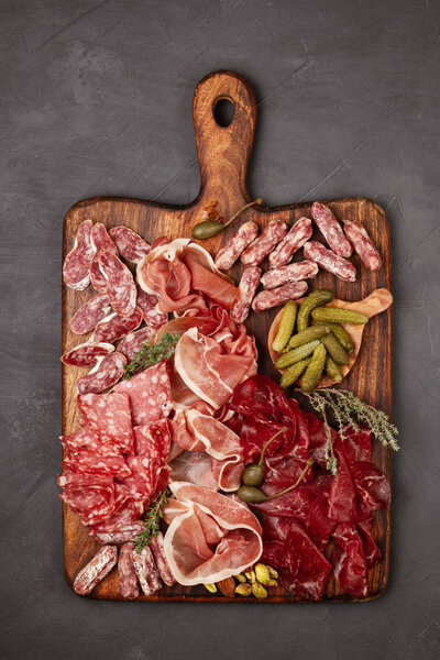 Appetizers table with differents antipasti, cheese, charcuterie, snacks and wine. Sausage, ham, tapas, olives, cheese and crackers for buffet party.