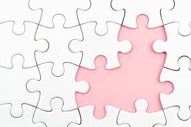Pembe arka planda beyaz yapboz ve kayıp parçalar. Tamamlanmamış ögeler, çözüm arama kavramı