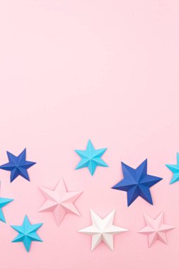 Renkli kağıt origami yıldızlarıyla soyut bir arkaplan. Tatil, kutlama, doğum günü, tebrik kartı, davetiye, konsept