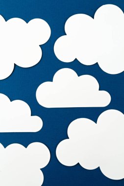 Beyaz kağıt mavi arkaplanda bulutları keser.