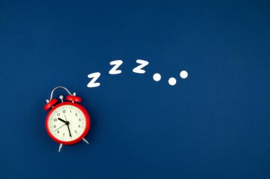 Mavi pastel arka planda klasik alarm saati horlaması. Düz yat, üstten bak, maket yap