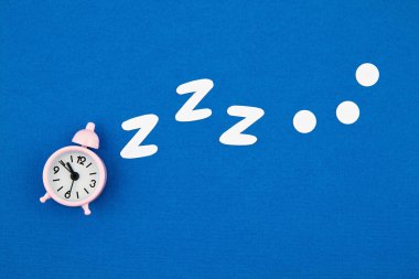 Mavi pastel arka planda klasik alarm saati horlaması. Düz yat, üstten bak, maket yap