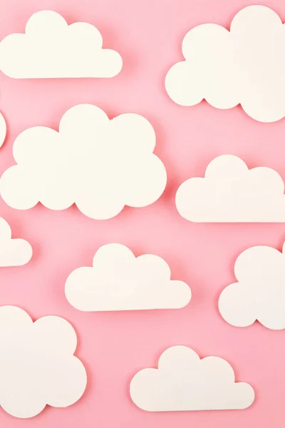 Papier blanc découpez les nuages sur fond rose . — Photo