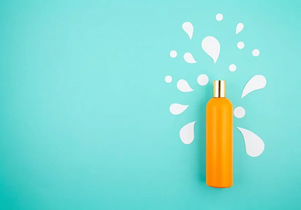 Cosmetic bottle on pastel modern paper background with paper cut splashes. Mock-up for product package branding